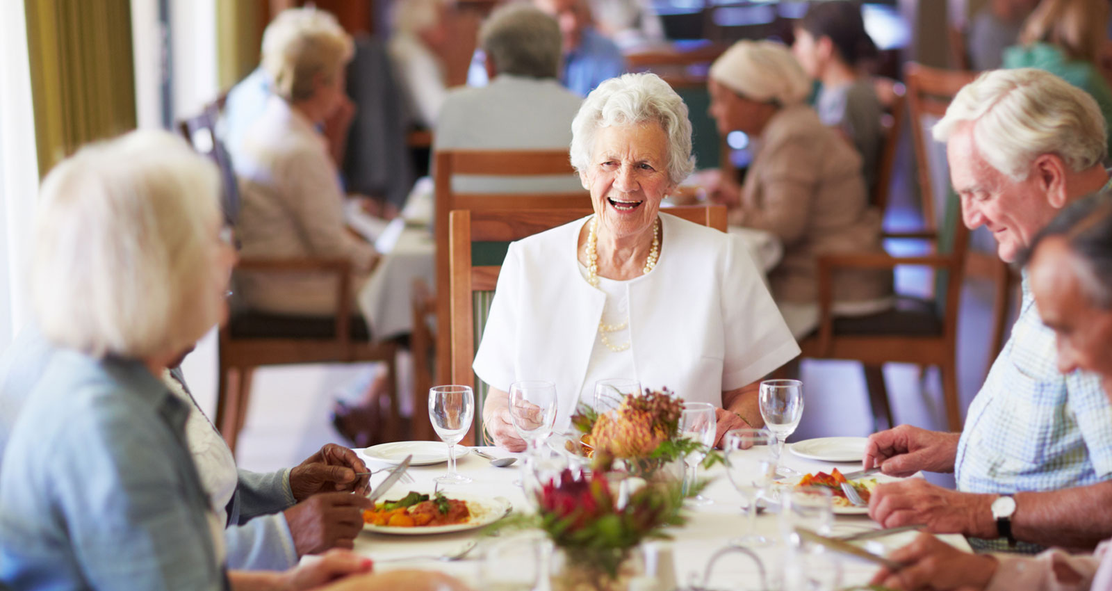 A group of elderly people having lunch together at a nursing home